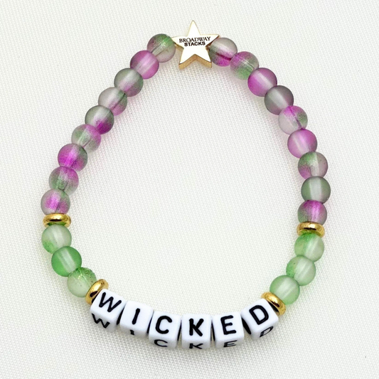 Broadway Stacks Witch collection. 3 stretch bracelets included in Stack. Greens, pinks, black and gold colored beads. Letter beads that spell Wicked. Gold star logo bead on every bracelet. 
