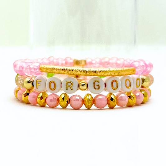 Broadway Stacks Witch collection. 3 stretch bracelets included in Stack. Greens, pinks, black and gold colored beads. Letter beads that spell Wicked. Gold star logo bead on every bracelet. 