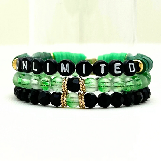 Broadway Stacks Witch collection. 3 stretch bracelets included in Stack. Greens, pinks, black and gold colored beads. Letter beads that spell Wicked. Gold star logo bead on every bracelet.