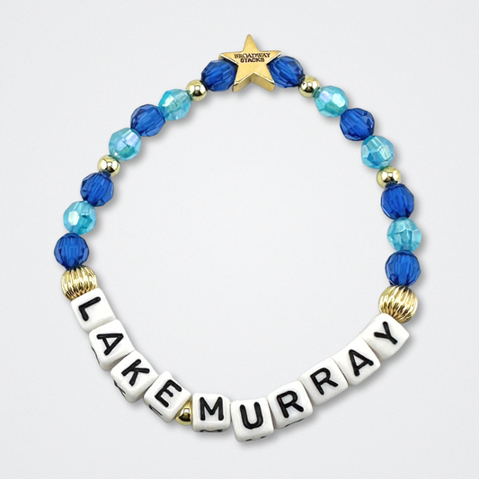 Broadway Stacks LAKE MURRAY bead bracelet. Dark blue, light blue and gold color beads on a gray background.