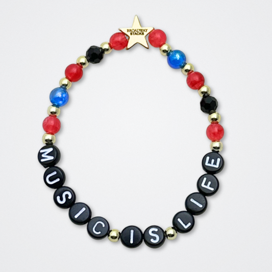 Broadway Stacks JAZZY Collection. 5 stretch bracelets included in Stack. Red, blue, black and gold colored beads. Letter beads that spell quotes. Gold star logo bead to remind you that you shine. Wonderful World musical and Louis Armstrong fans.